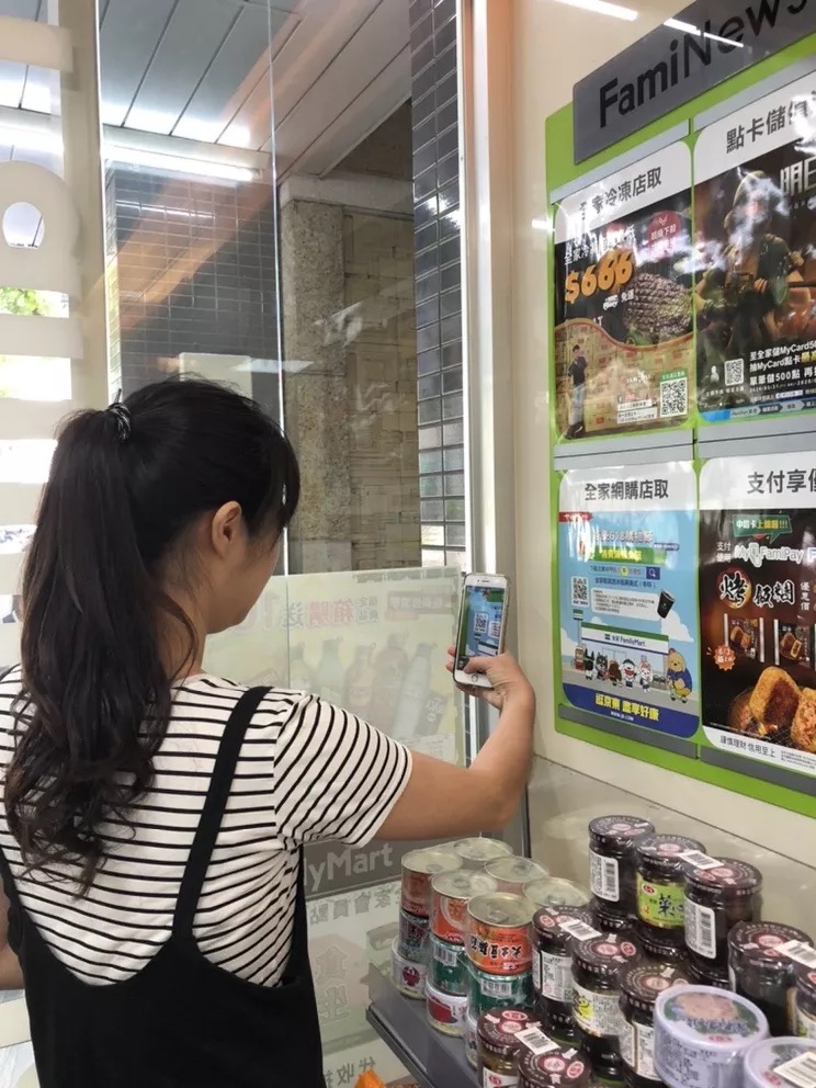 A customer scans JD code at a FamilyMart store.