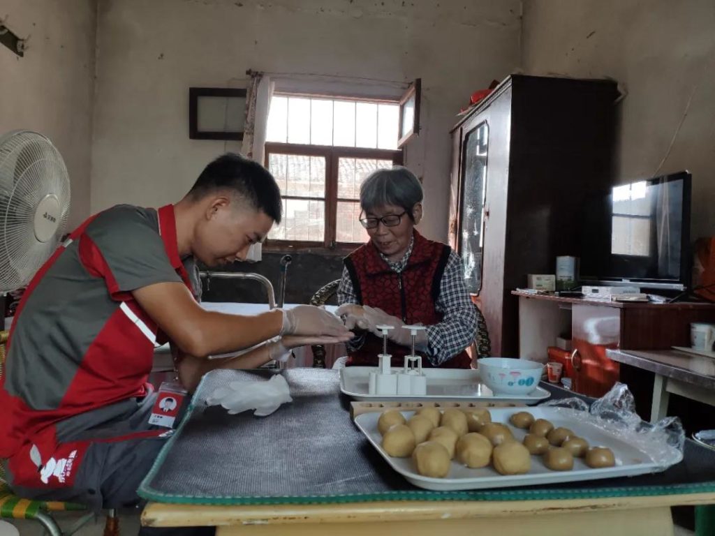 JD courier Qingfeng Wang and customer making mooncakes