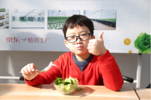 boy excitedly enjoys a salad with veggies from JD Plant Factory