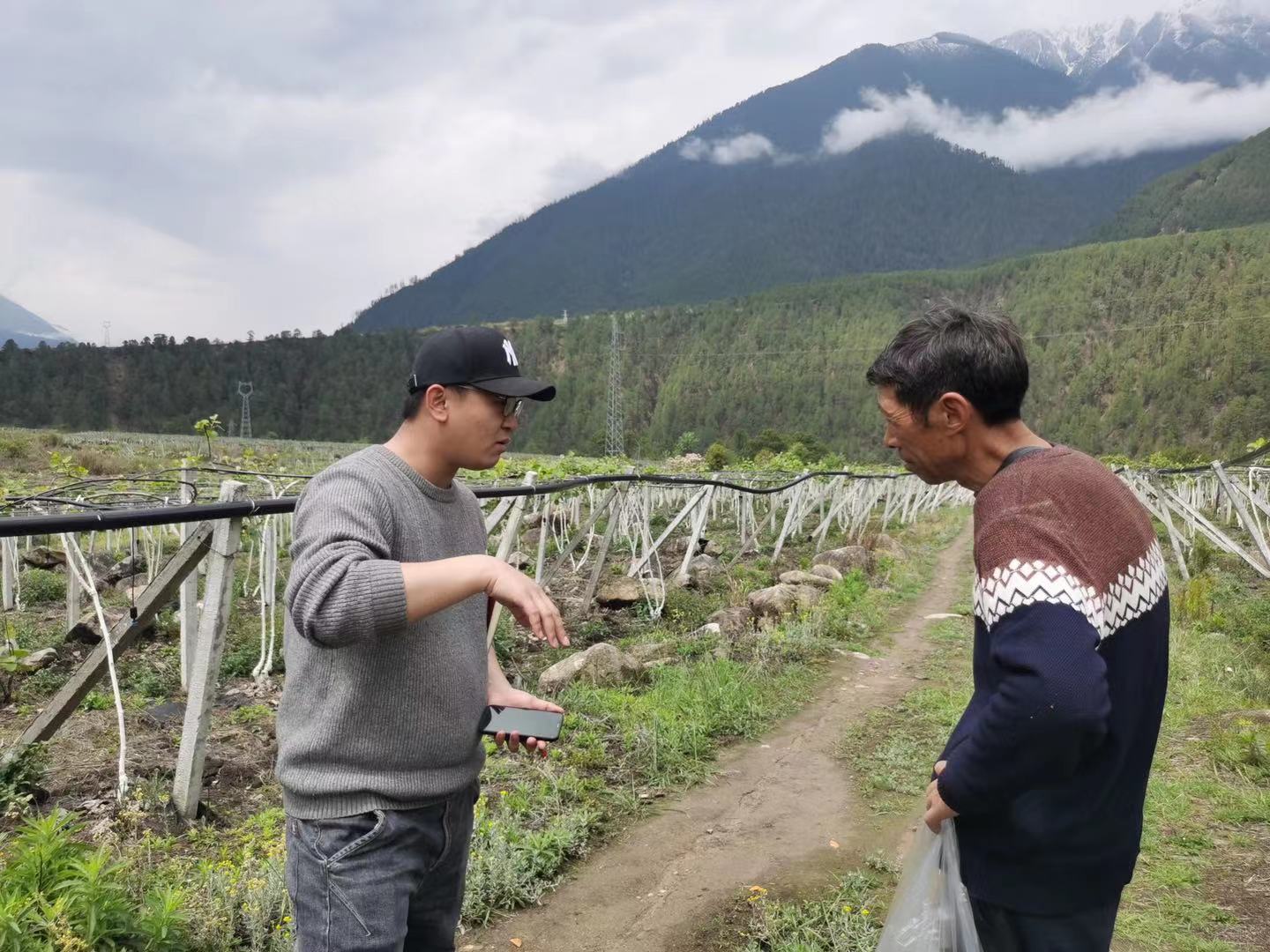 Xianfeng Wang (left) talks with a local farmer