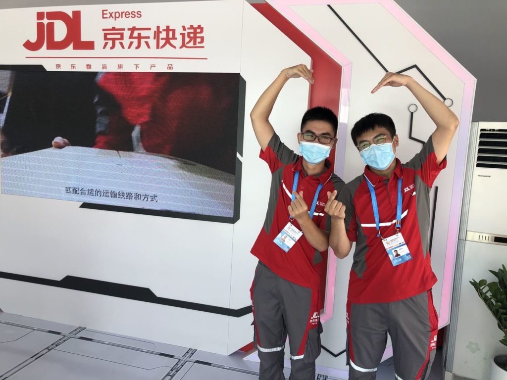D’s local couriers in Haikou, Kun Lin and Jianding Han, in JD Logistics’ makeshift delivery station at Hainan Expo